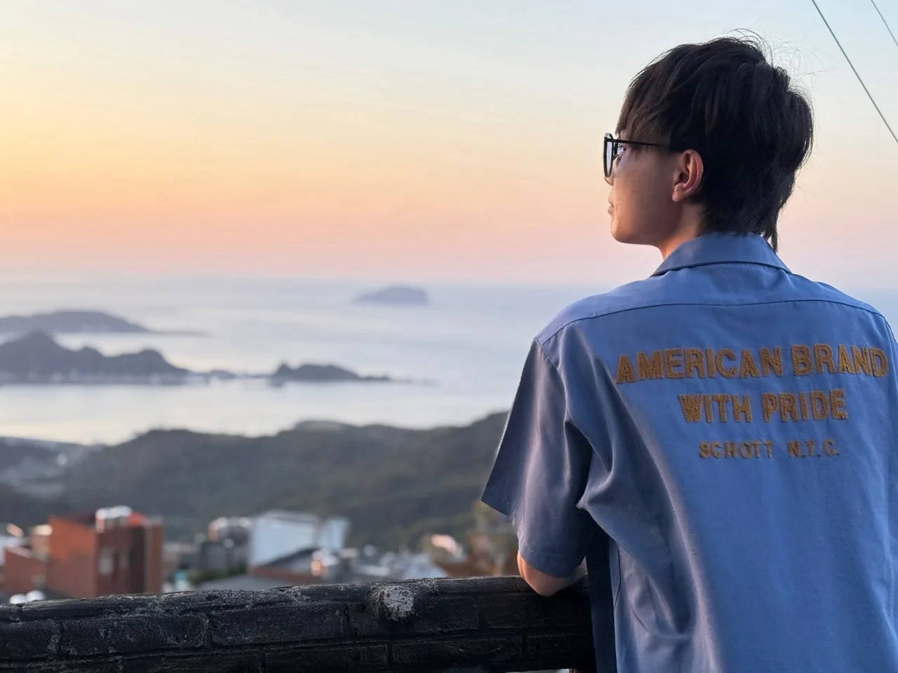 SCHOTTのシャツを着て夕景を眺める石川ハルト
